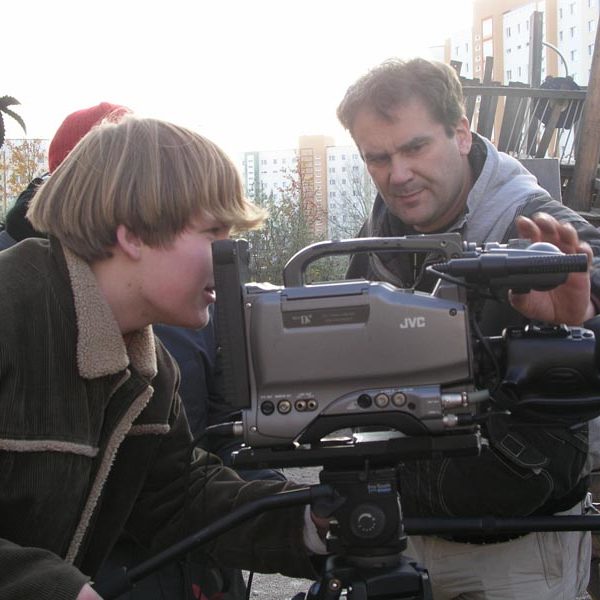 Projekt "Medienwerkstatt Rostock". Ein junger Mann und ein älterer bedienen eine Filmkamera.