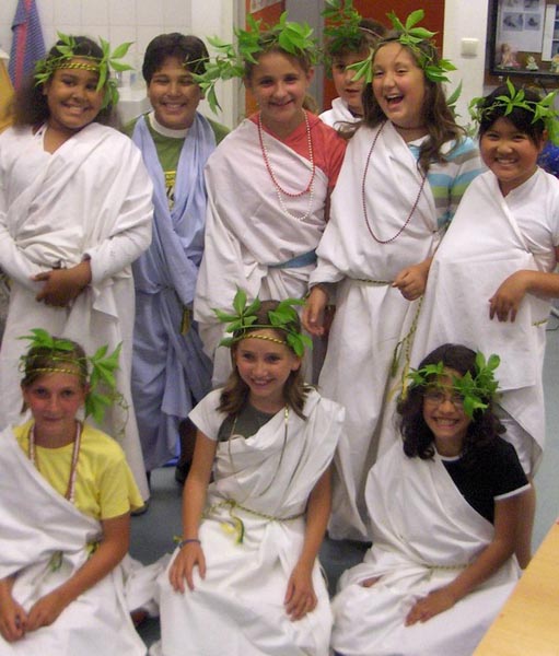 Projekt ""Odysseus Abenteuer" - eine multimediale Nacht für Kinder". Gruppenfoto einiger Mitwirkender des Projekts, welche weiße Roben und Lorbeerkränze auf den Köpfen tragen.