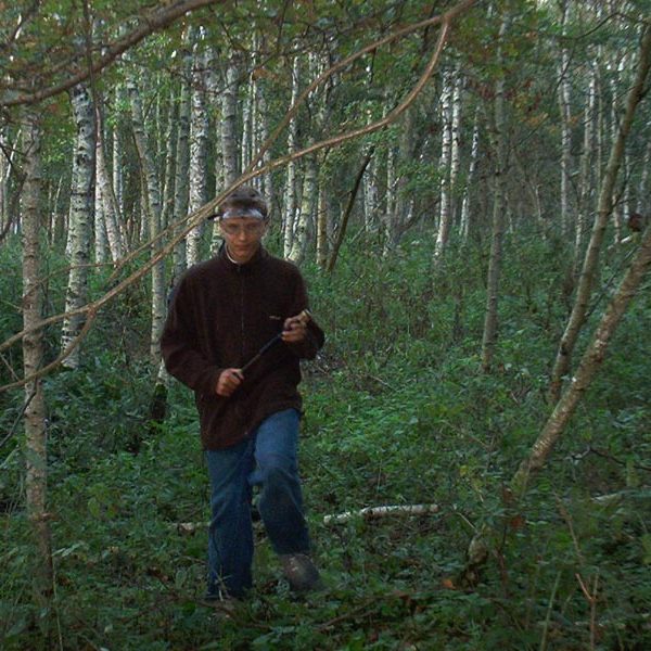 Projekt ""Hardliner" - Konzept". Ein Mann geht durch einen dicht bewachsenen Wald auf die Kamera zu.