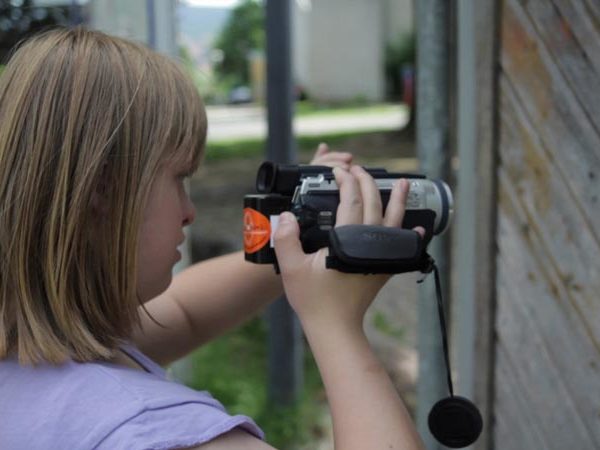 Projekt "Siehste Töne?! Hörste Bilder?!". Aufnahmen eines jungen Mädchens, welches einen Camcorder in der Hand hält.