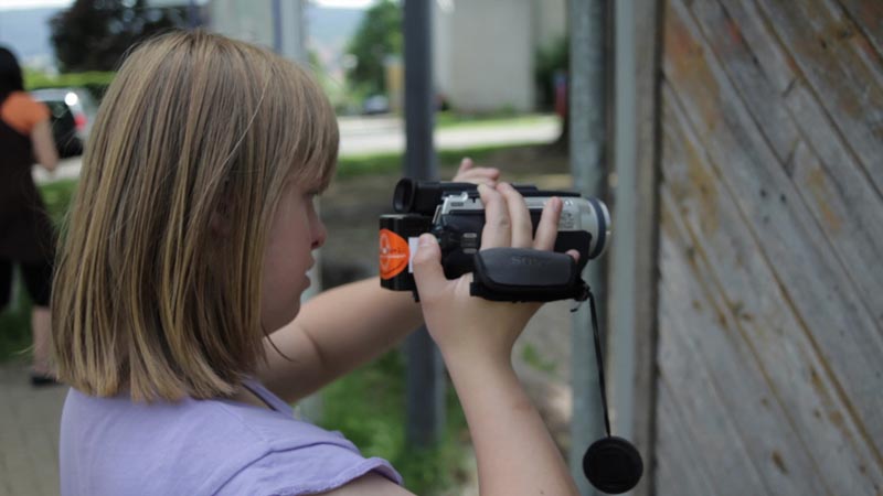 Projekt "Siehste Töne?! Hörste Bilder?!". Aufnahmen eines jungen Mädchens, welches einen Camcorder in der Hand hält.