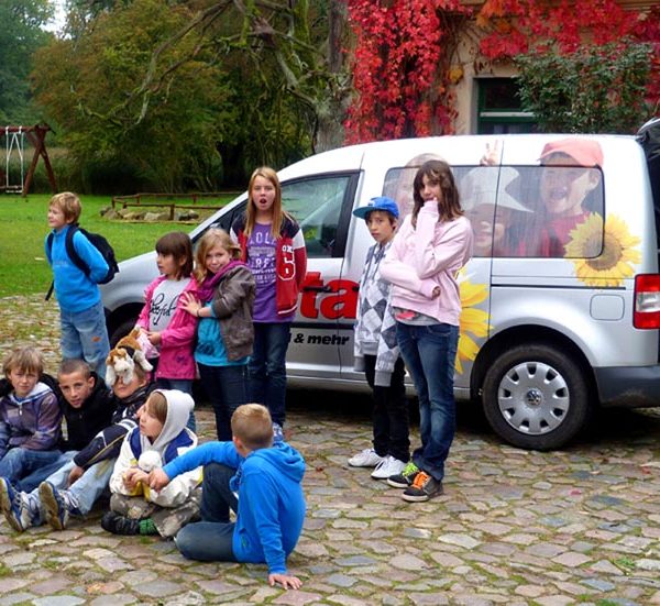 Projekt "m³ multimediamobil - Medienkompetenz für junge Menschen im Land Brandenburg". Foto einer Gruppe Kinder und Jugendlicher vor einem Van.