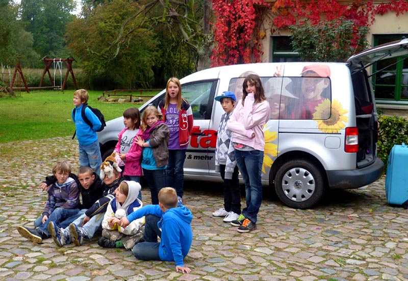 Projekt "m³ multimediamobil - Medienkompetenz für junge Menschen im Land Brandenburg". Foto einer Gruppe Kinder und Jugendlicher vor einem Van.