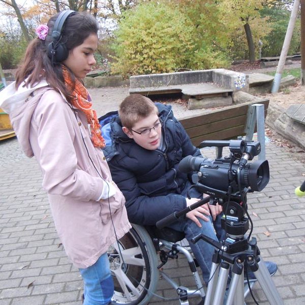 Projekt "Ausgeschlossen - Tatort Schule". Foto von zwei Jugendlichen, die mit Kamera und Kopfhörern ausgestattet sind.