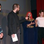 Dieter Baacke Preisverleihung 2016: Der Moderator und Mitwirkende des Projekts "Kino Asyl" stehen auf der Bühne.